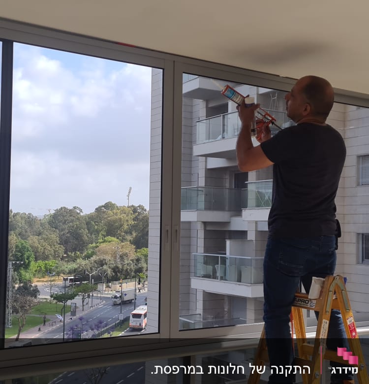 אדם עובד על מסגרת אלומיניום של חלון